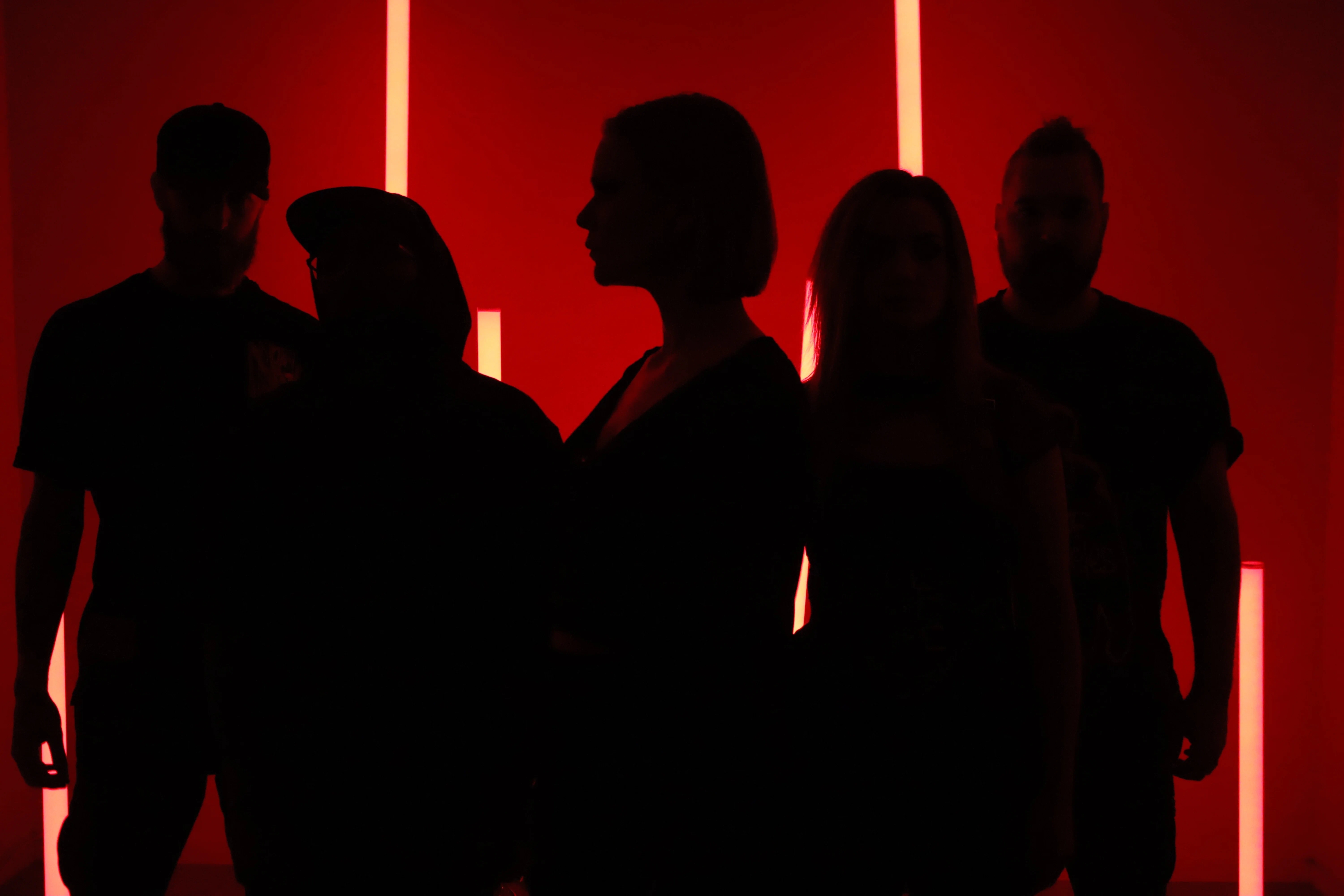 Group photo of Goodnight Greatness cloaked in shadow infront of a red neon background